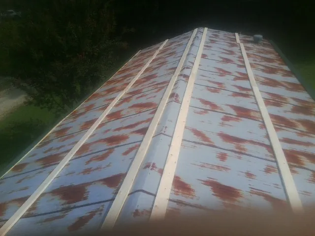 Rusted metal roof panels with new wood purlins before replacement — Storm Damage Roof Repair in Pleasant Valley by Roofing Brothers