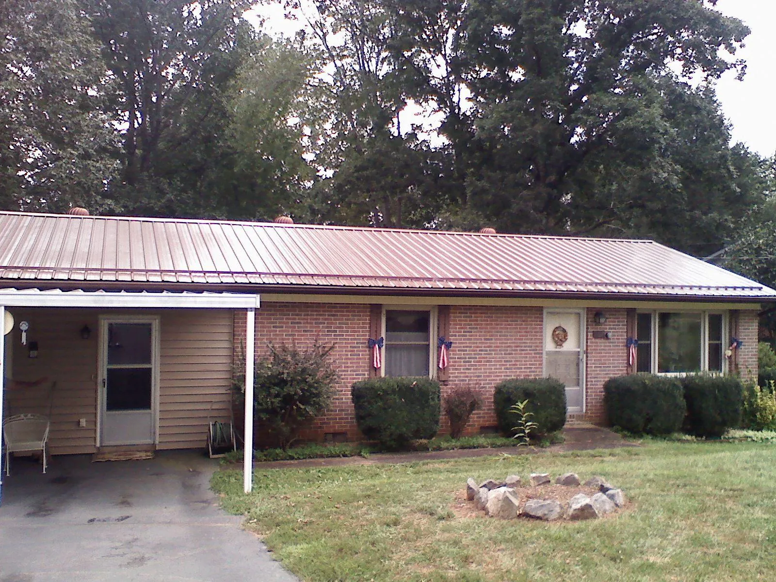 Bronze metal roof and carport on a brick ranch home — Roof Repair work by our crew in Pleasant Valley